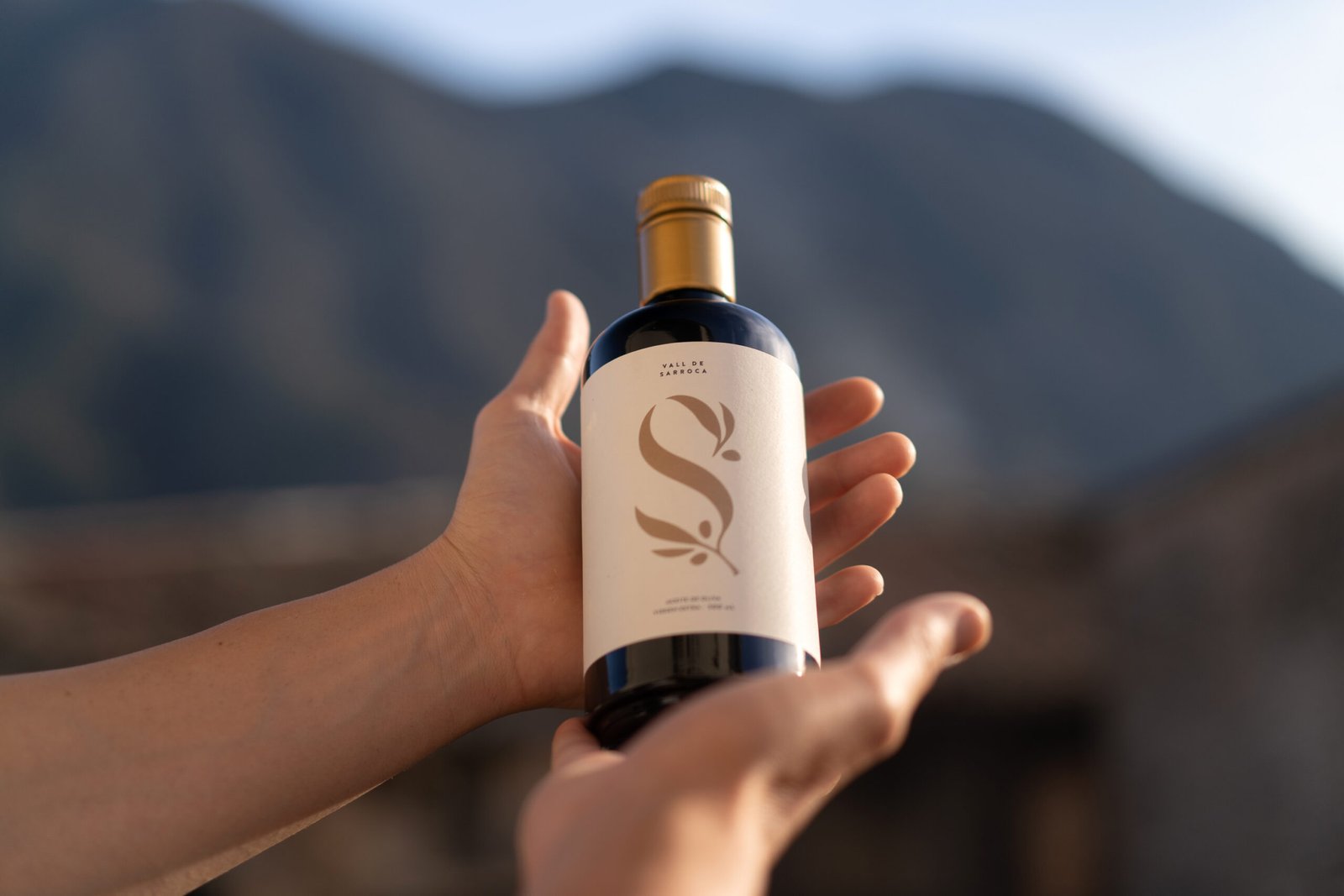 Botella_Cristal_Cocina_aceite de oliva virgen extra sostenida por manos